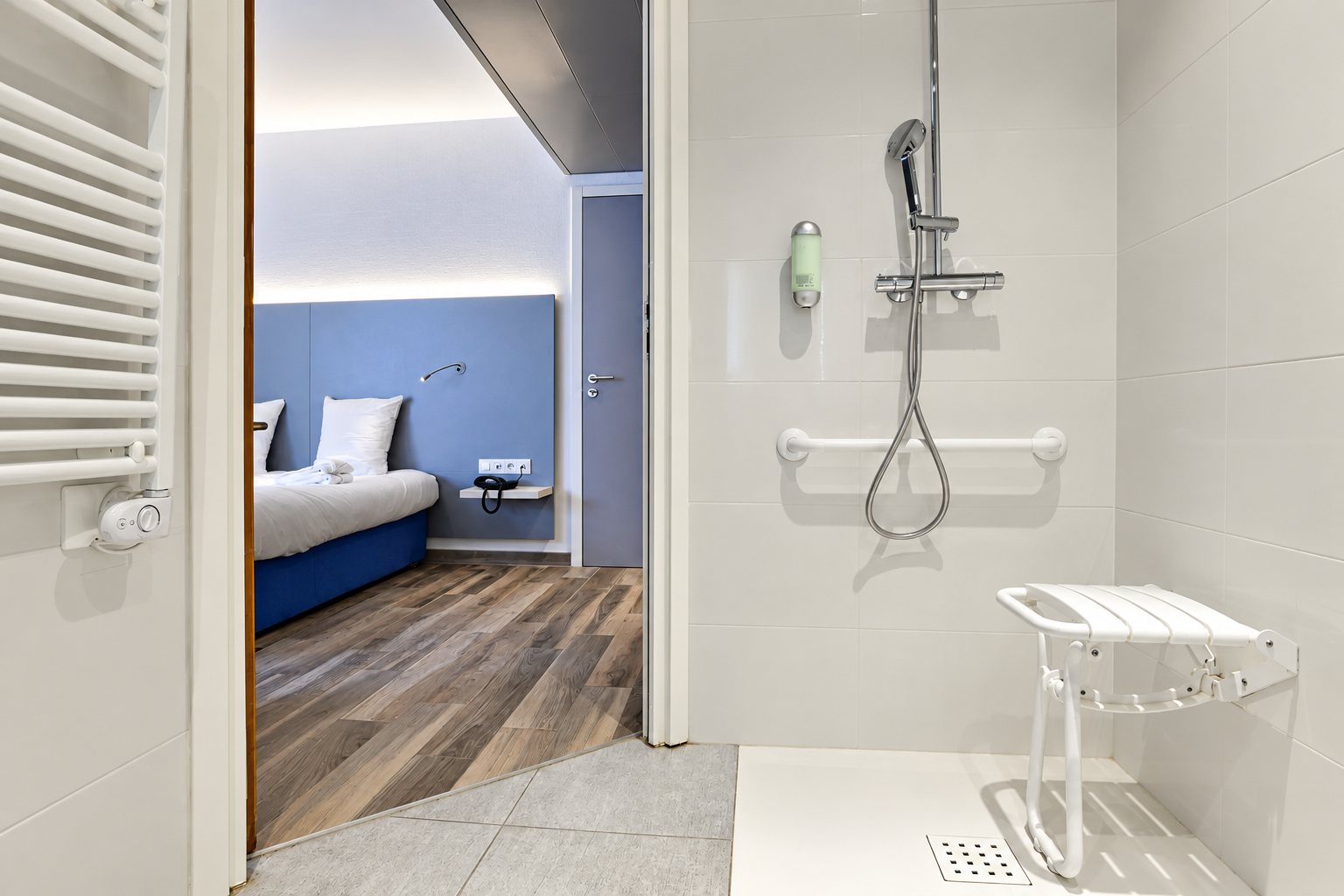 Douche accessible avec barres d'appui et siège