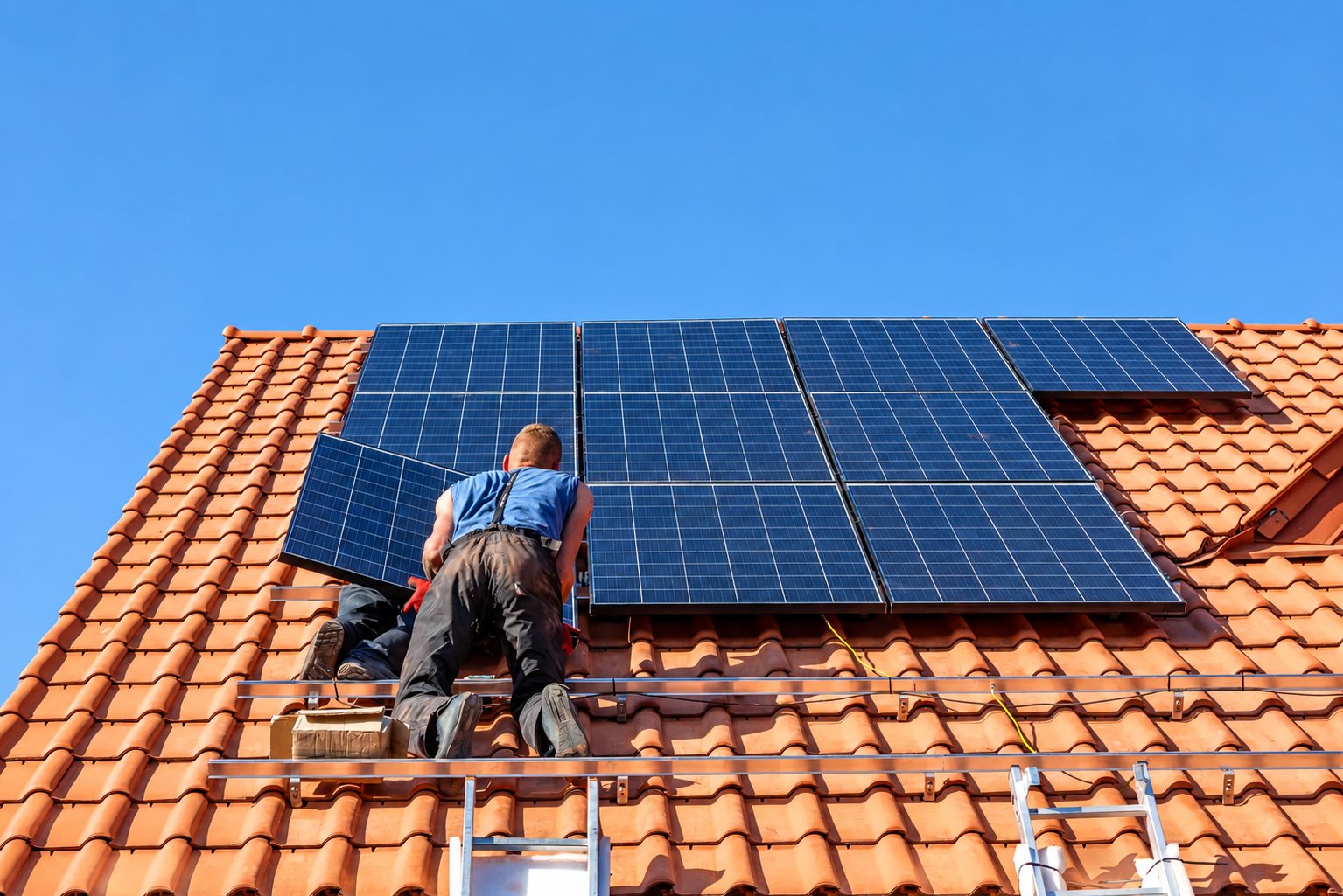 Pose de panneaux solaires sur un toit en tuiles